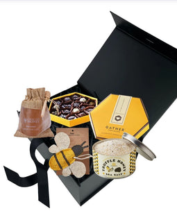 Bee Happy gift box featuring raw honey, honey truffle sea salt, artisan chocolates, and bee themed kitchen scrubber