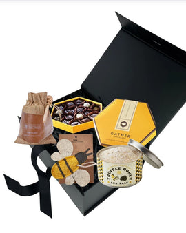 Bee Happy gift box featuring raw honey, honey truffle sea salt, artisan chocolates, and bee themed kitchen scrubber