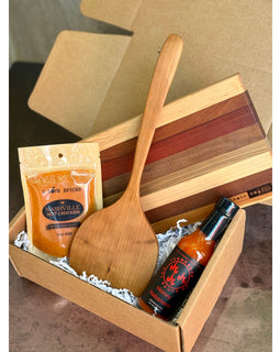Nash Grill Gift Box with Petit Cutting Board, wooden flipper, Nashville Hot Chicken Spice, and Honey Habanero Hot Sauce arranged in kraft box