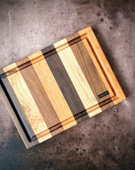 Handcrafted cocktail bar board made from cherry, maple, sapele, and walnut with juice groove for preparing cocktail garnishes