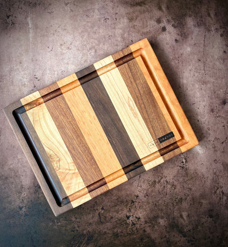 Handcrafted cocktail bar board made from cherry, maple, sapele, and walnut with juice groove for preparing cocktail garnishes