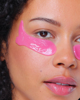 Close-up of a person wearing pink eye masks on their face.