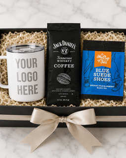 Gift set with a mug, coffee package, and tea package in a box on a marble surface.