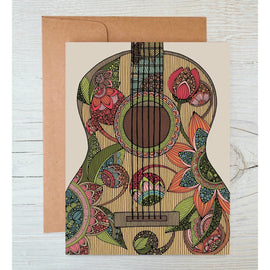Greeting card featuring a colorful guitar illustration by Valentina Harper, blank inside, shown with a kraft envelope on a wooden surface.