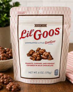Packaging of Lil' Goos chocolate clusters with a bowl of clusters and a pink cloth in the background.