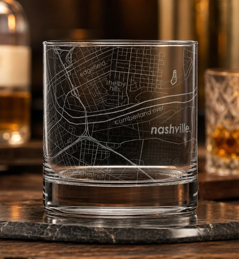 Clear glass with engraved map of Nashville on a wooden surface with blurred background