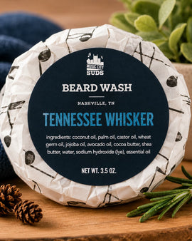 Beard wash product with 'Tennessee Whisker' branding on a wooden surface with decorative elements.