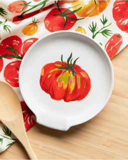 Stoneware spoon rest with colorful heirloom tomato print in red, orange, yellow, and green, featuring a center divot for resting utensils.