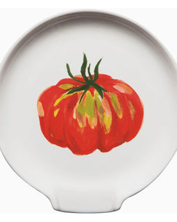 Stoneware spoon rest with colorful heirloom tomato print in red, orange, yellow, and green, featuring a center divot for resting utensils.